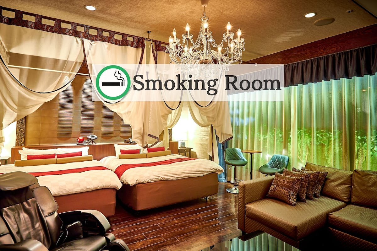 Ein Raucherzimmer mit Bett, Sofa, Massagesesseln und einer Chandelüster.