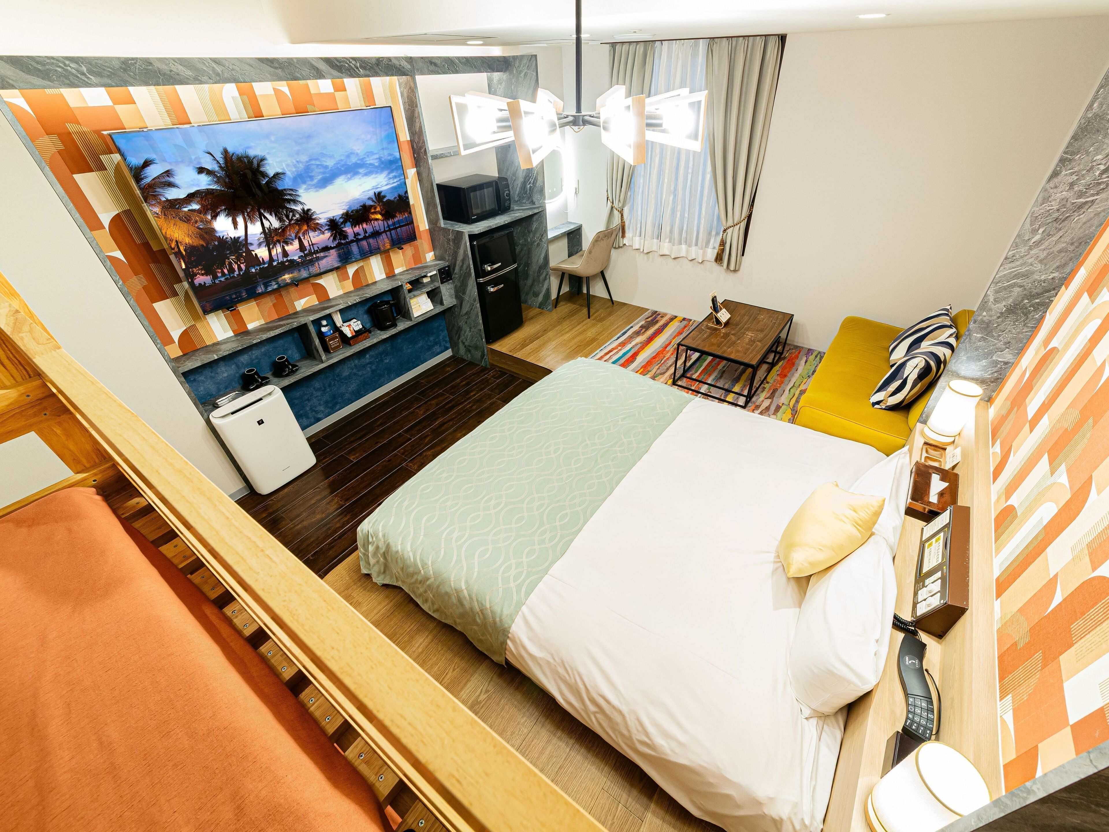 Une chambre d’hôtel équipée d’un lit, d’un bureau, d’une chaise, d’une télévision et d’un mini-bar.