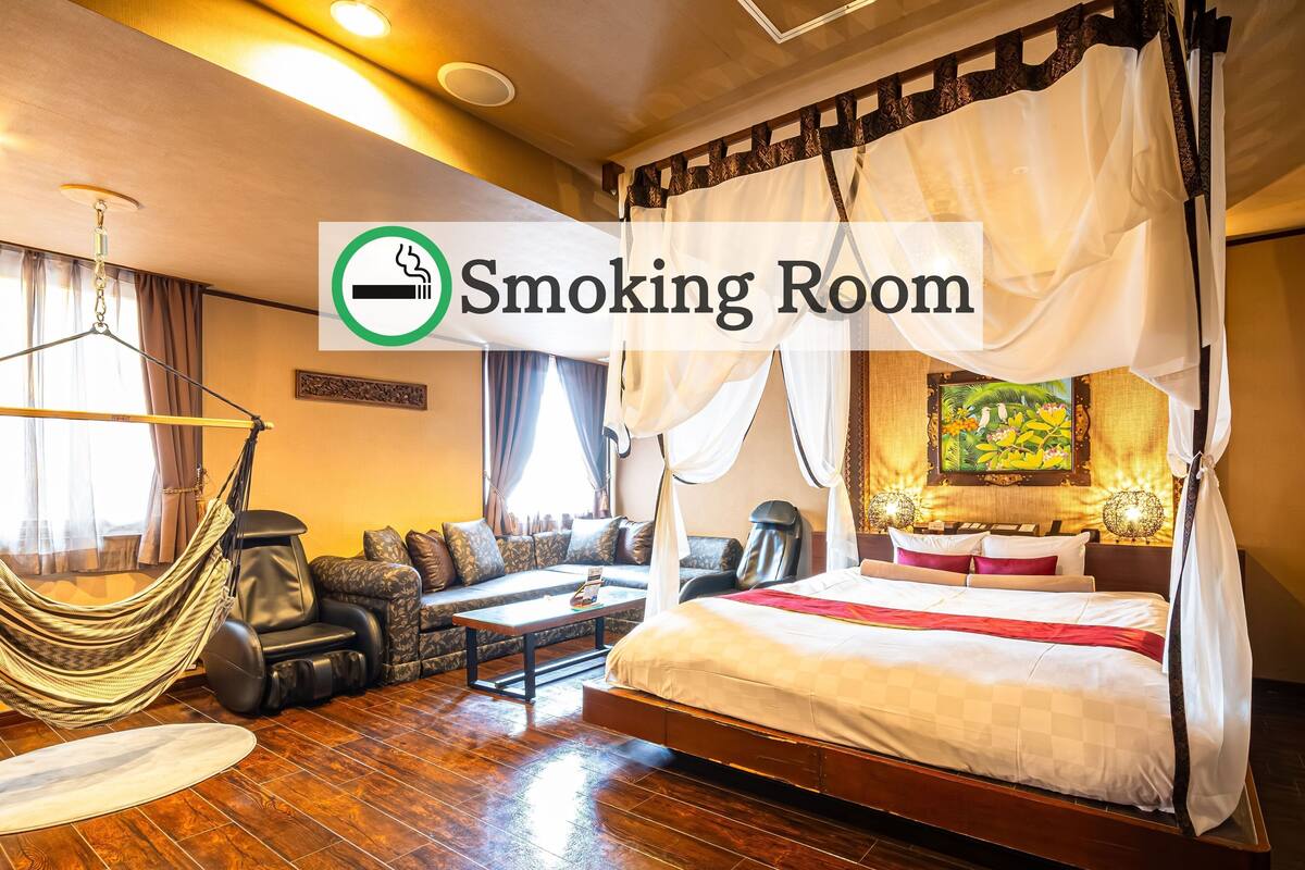 Ein Hotelzimmer mit Bett, Sofa, Massagesessel und Hängematte.