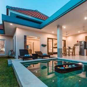 A modern house with a swimming pool, a dining area, and a kitchen. - Kubu Petitenget Suite Seminyak (Keroboken Kelod)