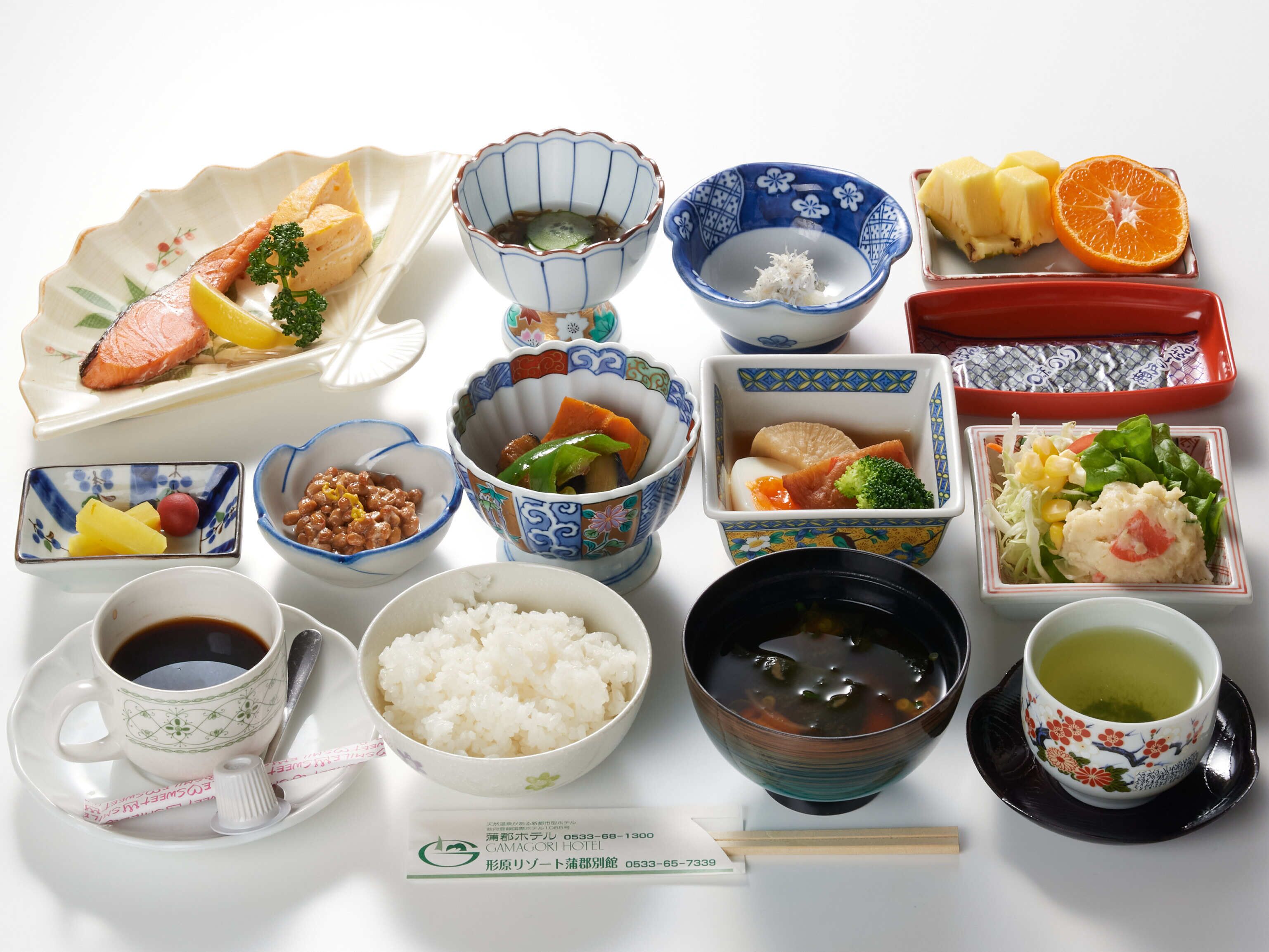 Verschiedene japanische Gerichte, darunter Sushi, Reis und Suppe, sind auf einem Tisch angerichtet.
