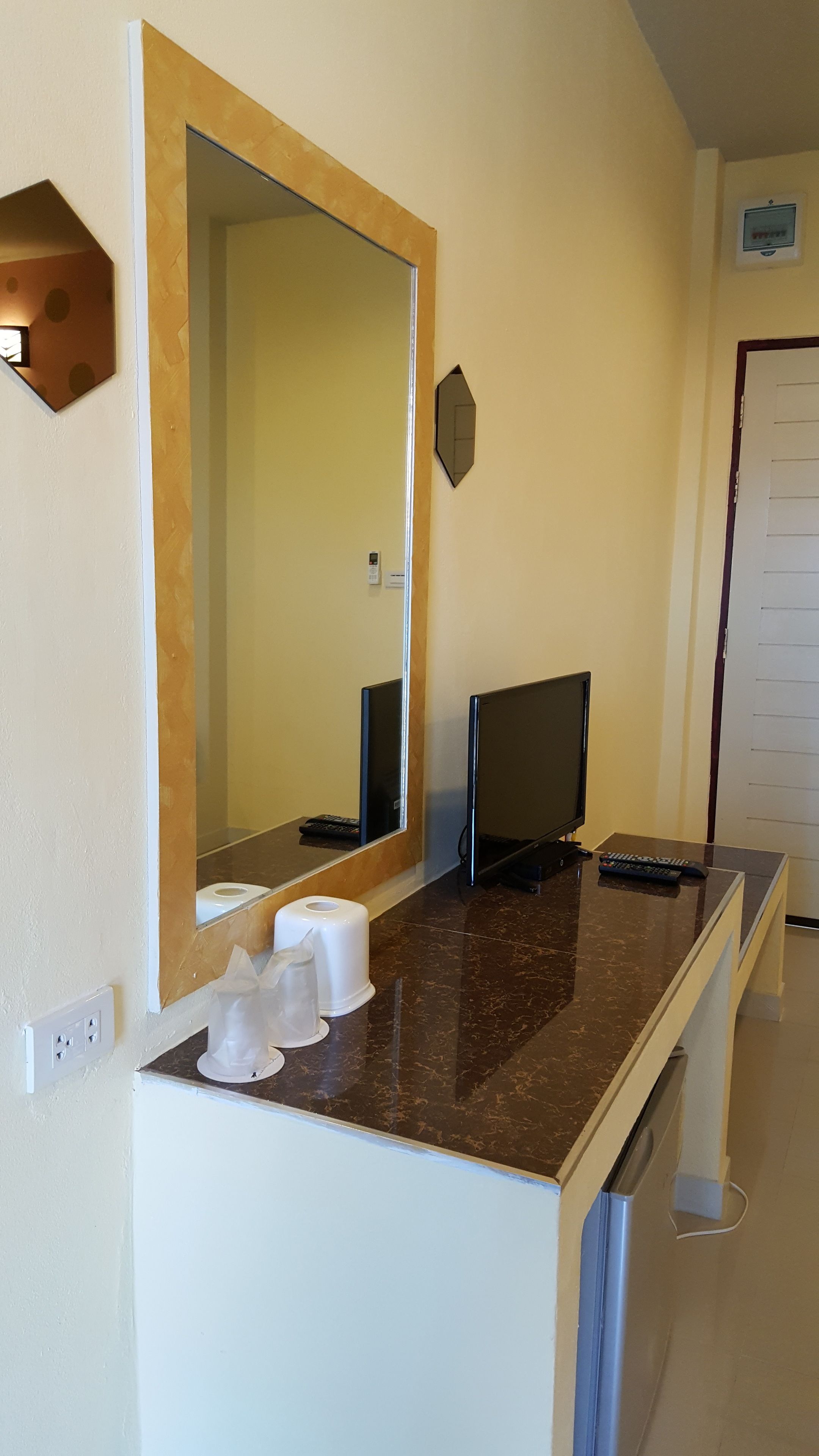 Un baño con un espejo grande, un lavabo, dos inodoros y una zona de ducha.
