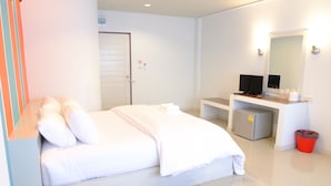 A hotel room with a bed, a desk with a computer, a mirror, and a trash bin. - Juntima Place at Amphawa (Amphawa)