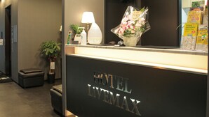 A hotel reception desk with a lamp, a flower arrangement, and a map of Tokyo. - Hotel Livemax Tokyo Bakurocho (Tokyo)