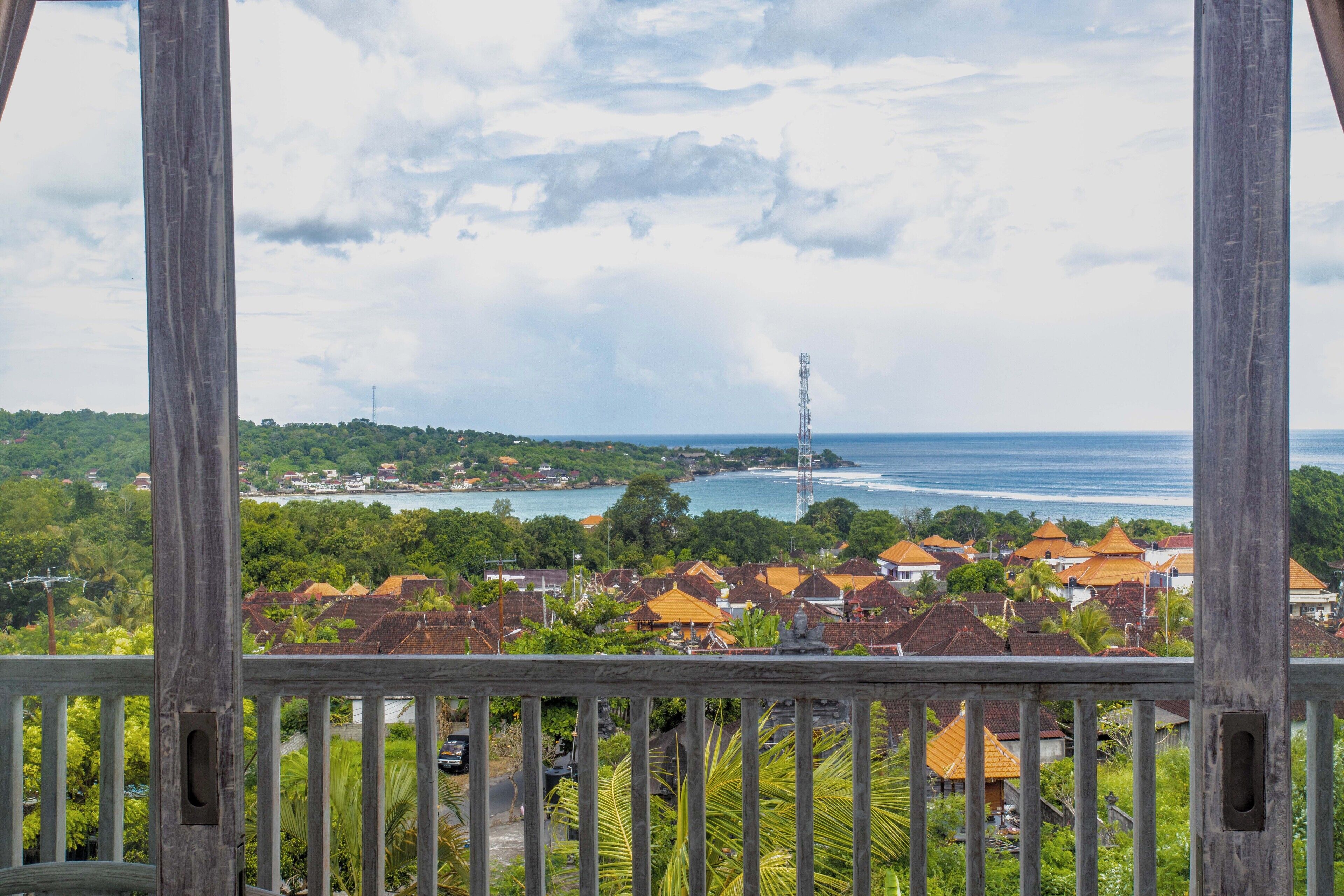 A coastal town with a view of the sea and a tall communication tower.