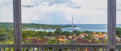 A coastal town with a view of the sea and a tall communication tower.