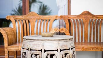 A wooden bench with intricate carvings and a stone table in front.