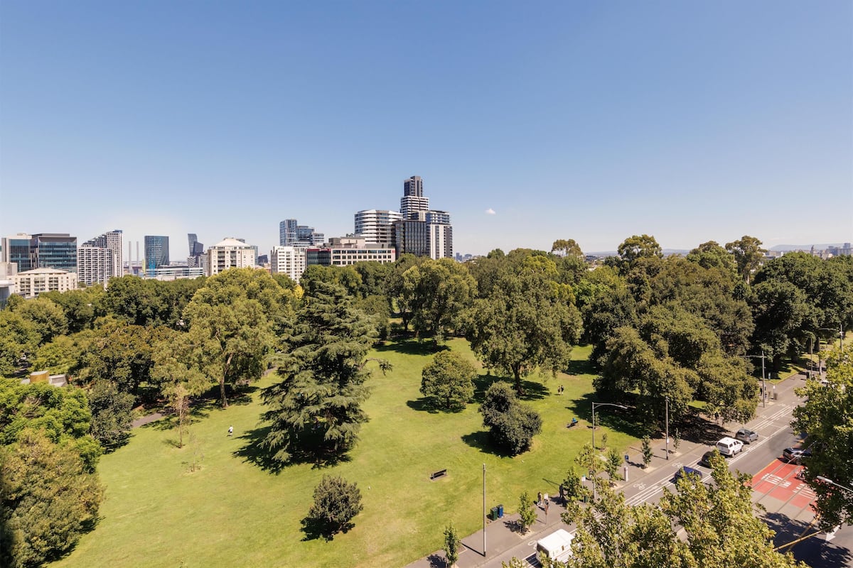 A cityscape with modern buildings and a large green park area.