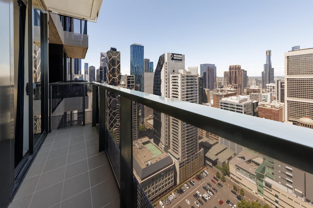A high-rise building with a balcony overlooking a cityscape.