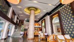 A spacious lobby with a central column, seating area, and a staircase leading to upper floors. - Viva Hotel Songkhla (Songkhla)