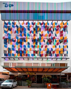 A modern building with a colorful facade featuring geometric patterns and a large entrance with steps.
