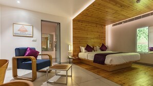 Une chambre moderne avec un plafond en bois, un lit avec une literie blanche et des oreillers violets, un canapé bleu avec un oreiller violet et une petite table en bois.