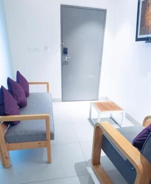 A modern room with a grey sofa set, a wooden bench, and a small table.