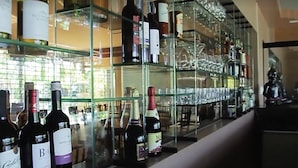 A wine cellar with shelves of wine bottles and glasses. - Buddha Resort by Cocotel (Bugallon)