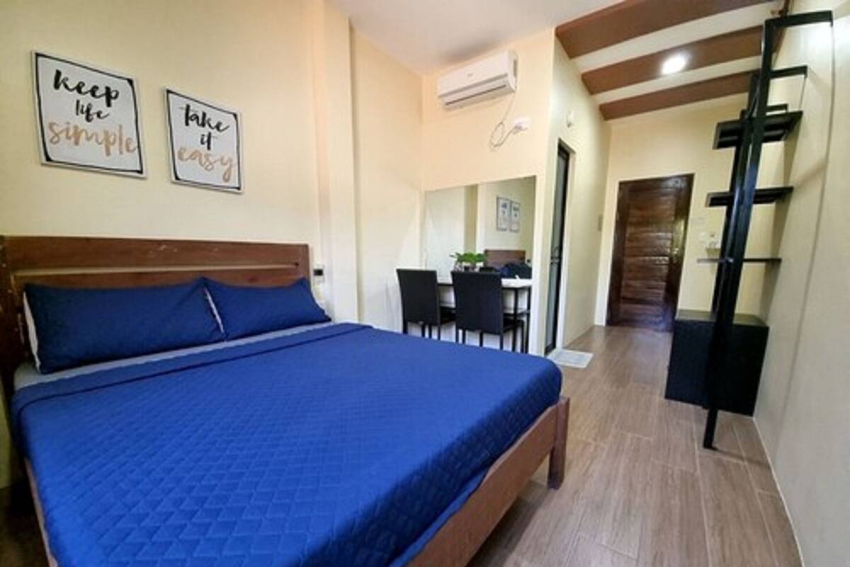 A bedroom with a bed, a desk, and a chair.