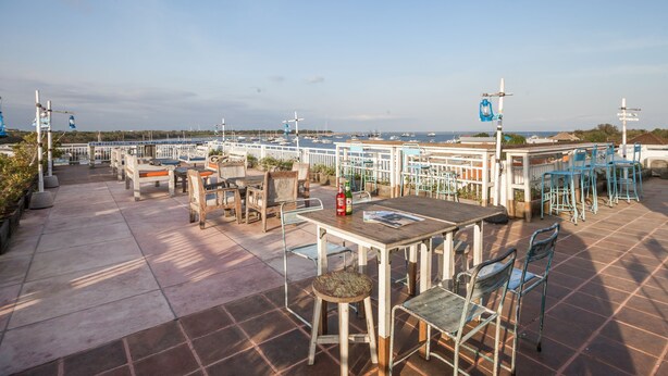 A rooftop terrace with outdoor seating, a view of the sea, and a sign indicating a smoking area. - Paras Paros Marina Lodge (Serangan)