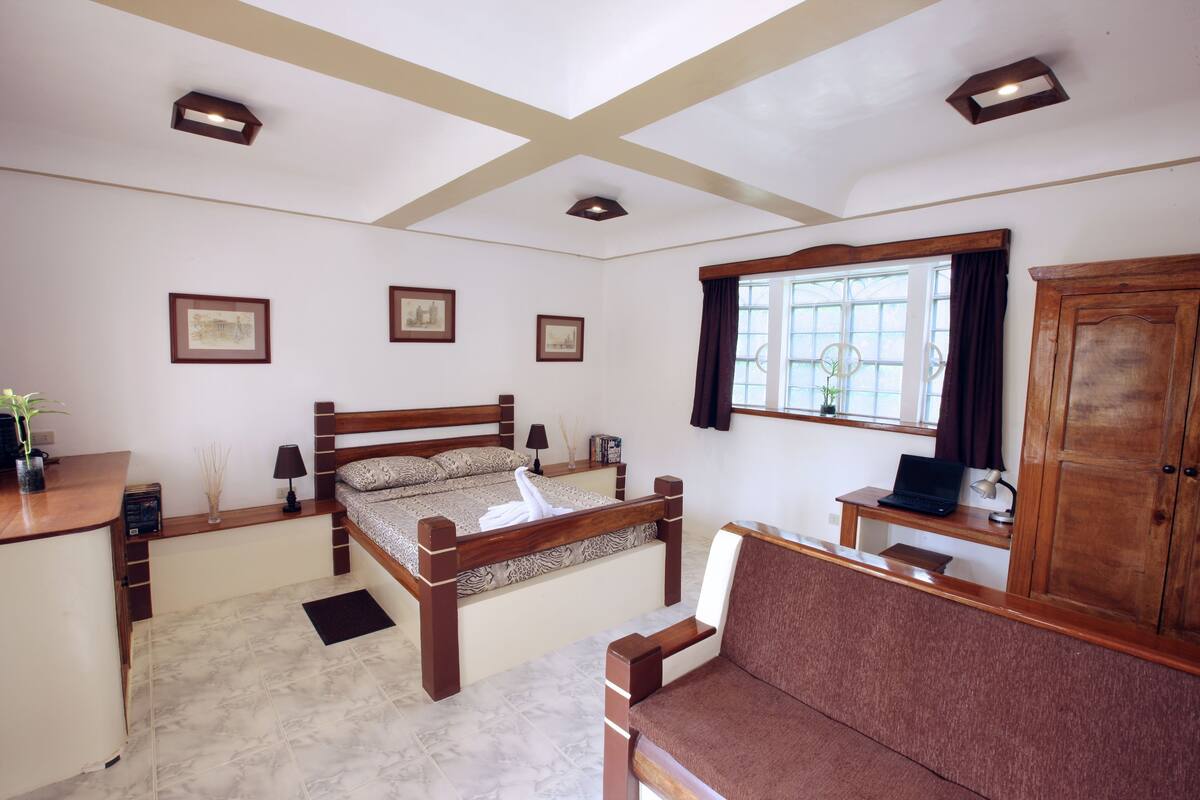 A bedroom with a bed, a desk, a chair, and a wardrobe.