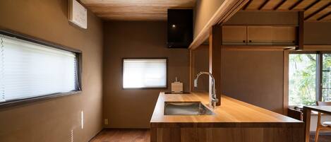 A compact kitchen with wooden countertops, a built-in sink, and a ceiling fan.