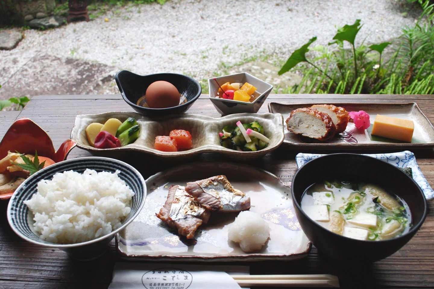 A traditional Japanese meal with rice, grilled fish, and various side dishes.
