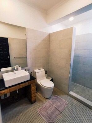 A bathroom with a large sink, toilet, and a glass shower enclosure. - 4poolvillas (Pattaya)
