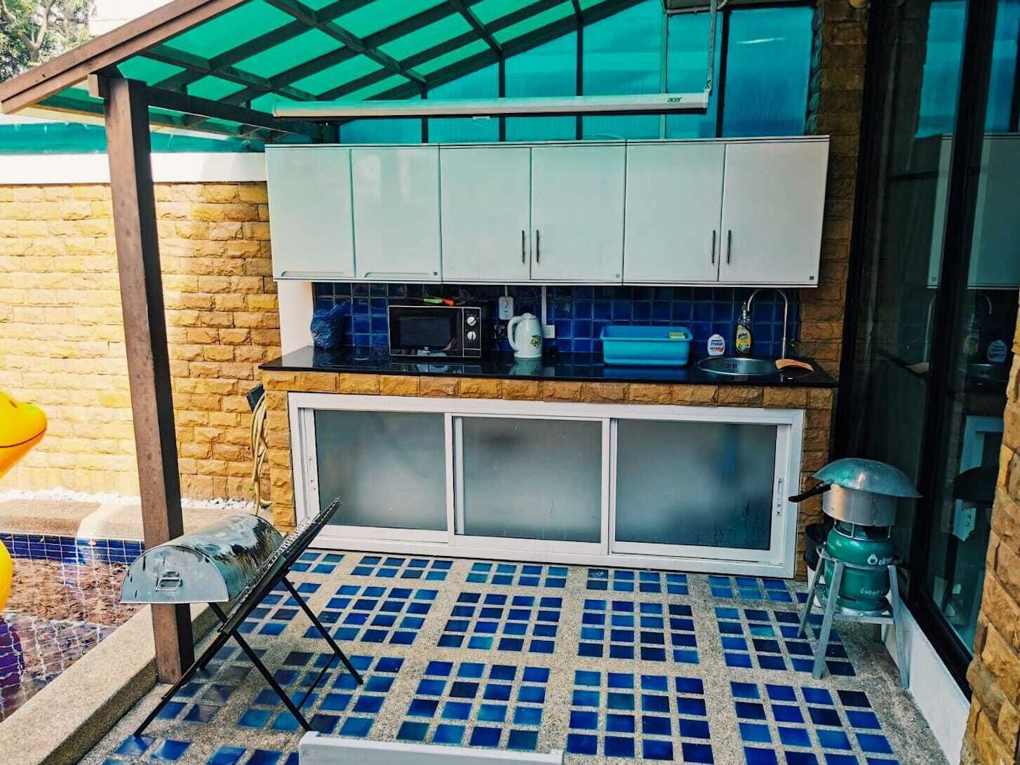 A compact kitchen with a tiled backsplash, a built-in microwave, and a gas stove.