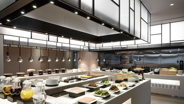 Una moderna presentación tipo buffet con diversas estaciones de comida y cristalería.