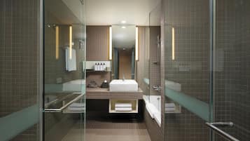 A modern bathroom with a glass shower enclosure, a vanity with a sink, and a bathtub.