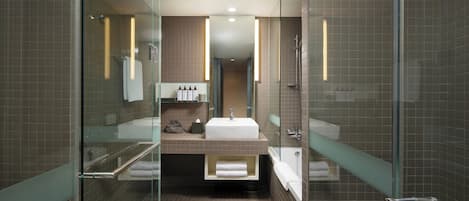 A modern bathroom with a glass shower enclosure, a vanity with a sink, and a bathtub.