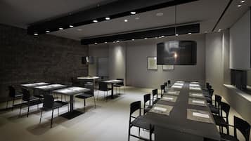 A modern conference room with a long table, multiple chairs, and recessed lighting.
