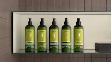 Un estante de baño con cinco botellas de productos Vervine L'OCCITANE.