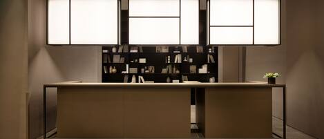 A modern reception desk with a minimalist design, featuring a neutral color palette and a clean, organized layout.