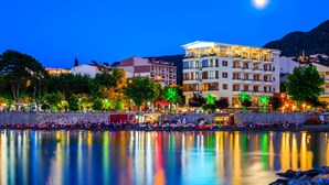 Un hotel frente al agua con varios pisos, balcones y vistas al mar.
