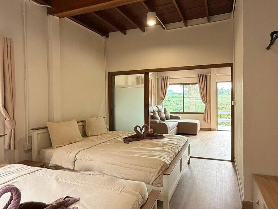 Ein Hotelzimmer mit einem großen Bett, einem Deckenventilator und Blick ins Freie.