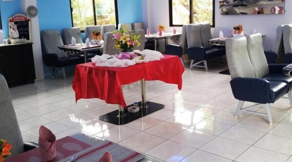 A dining area with a red table, chairs, and a menu sign. - Aerostop Hotel & Restaurant (Plaridel)
