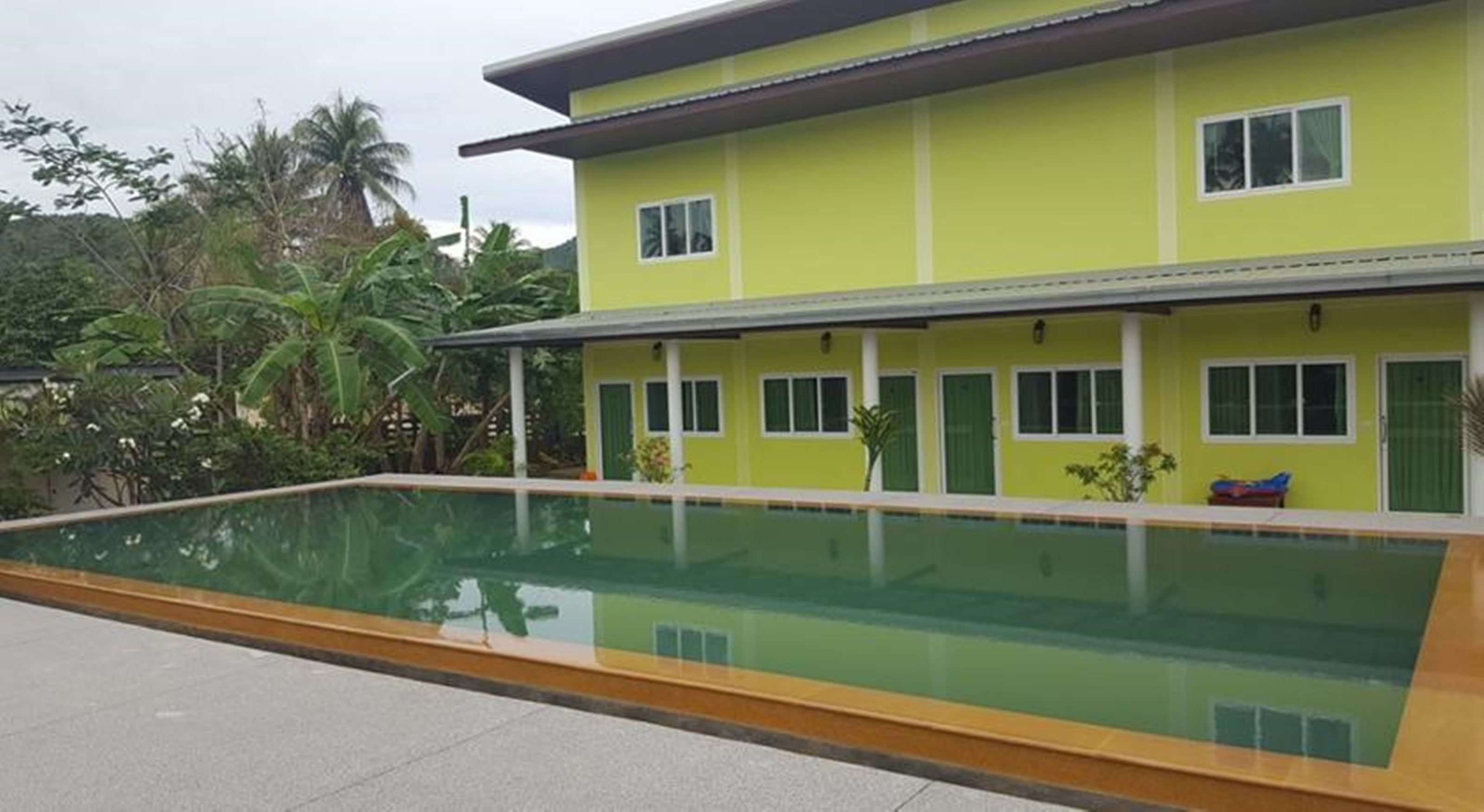 A two-story building with a swimming pool in front.