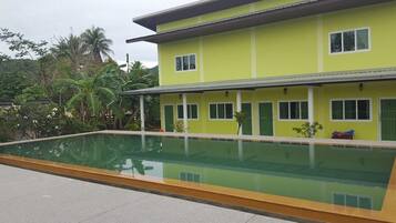 A two-story building with a swimming pool in front.