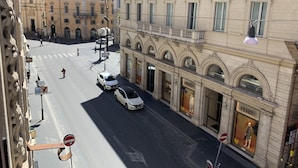 Une vue de rue avec une boutique Fendi, un ciel dégagé et un passage piéton.