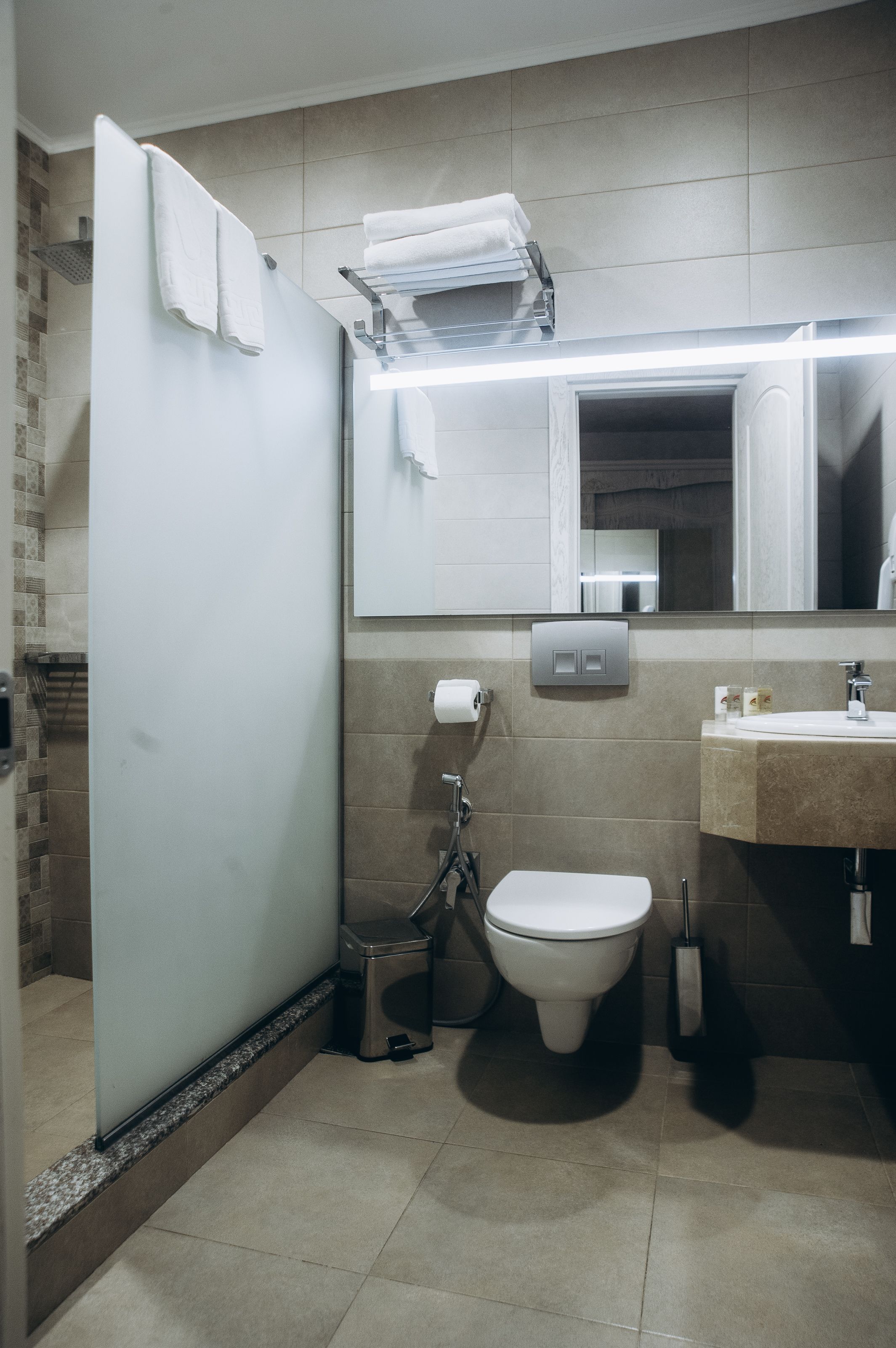 A modern bathroom with a toilet, sink, and towel rack.