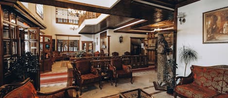 A spacious lobby with high ceilings, wooden beams, and classic furniture.