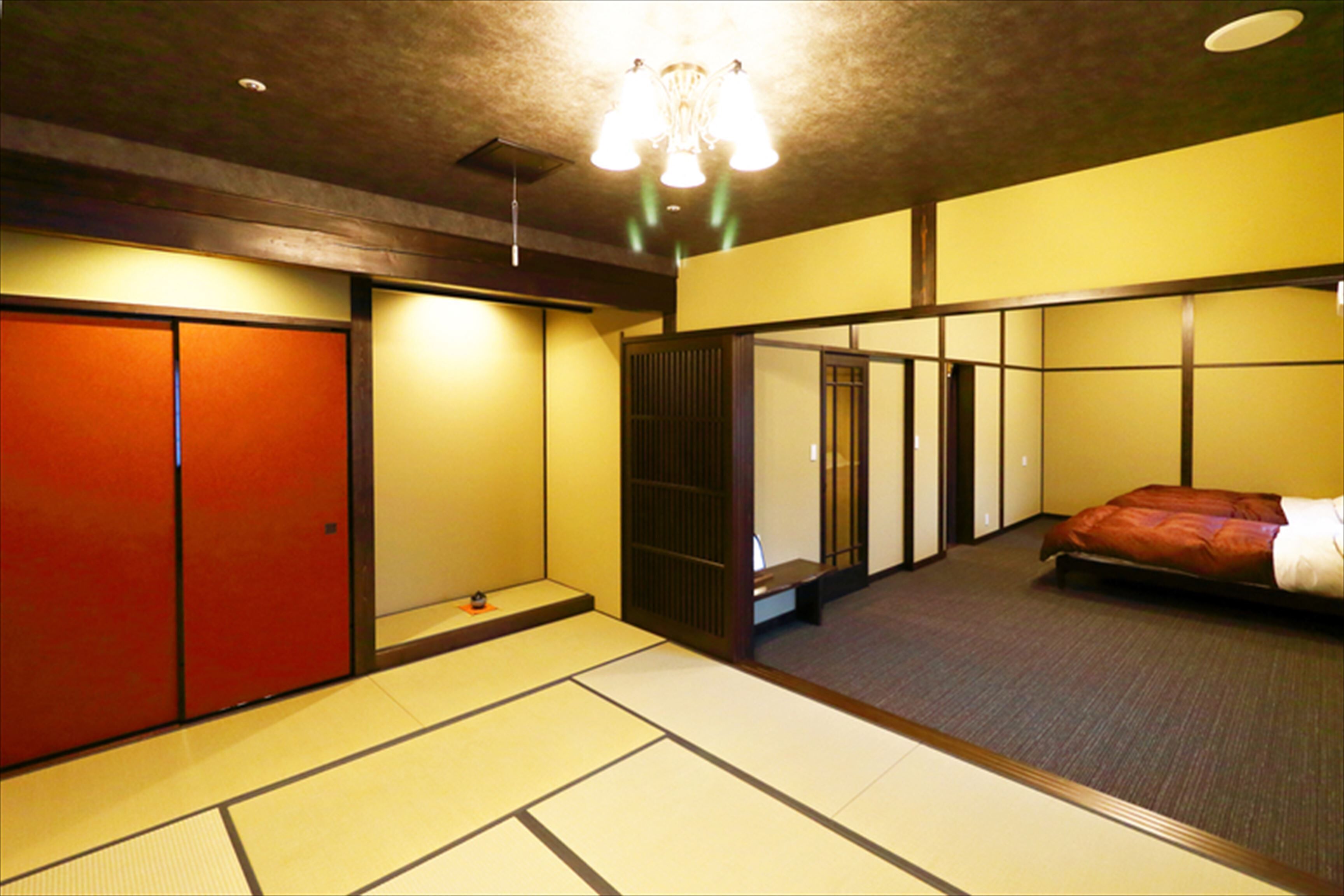 A traditional Japanese-style room with tatami flooring, a futon bed, sliding doors, and a ceiling light fixture.