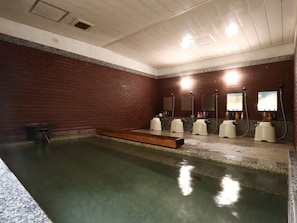 A public restroom with a pool, multiple sinks, and hand dryers.