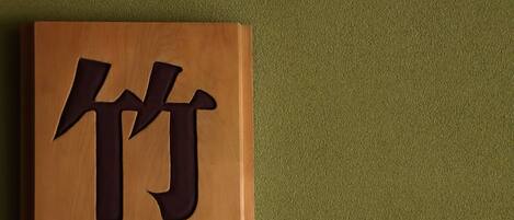 A wooden plaque with a dark inscription on a green textured background.