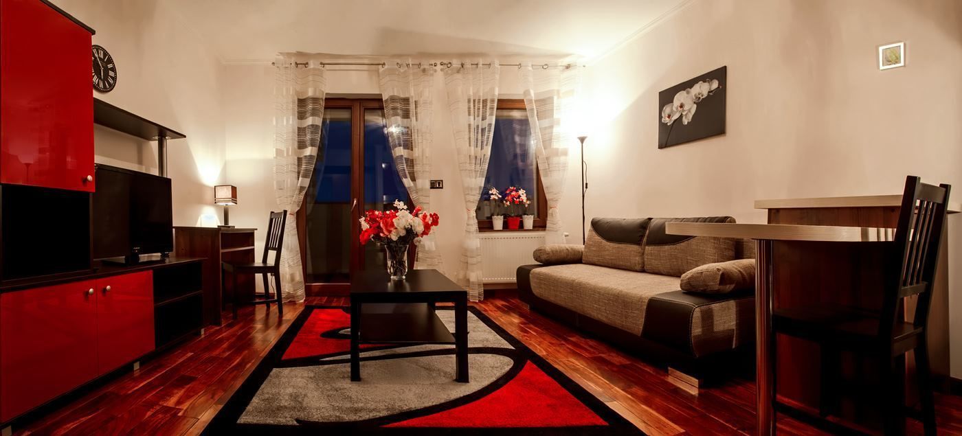 A modern living room with a sofa, a dining table, and a TV.