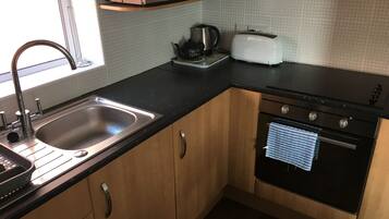 A kitchen with a sink, a microwave, a toaster, and an oven.