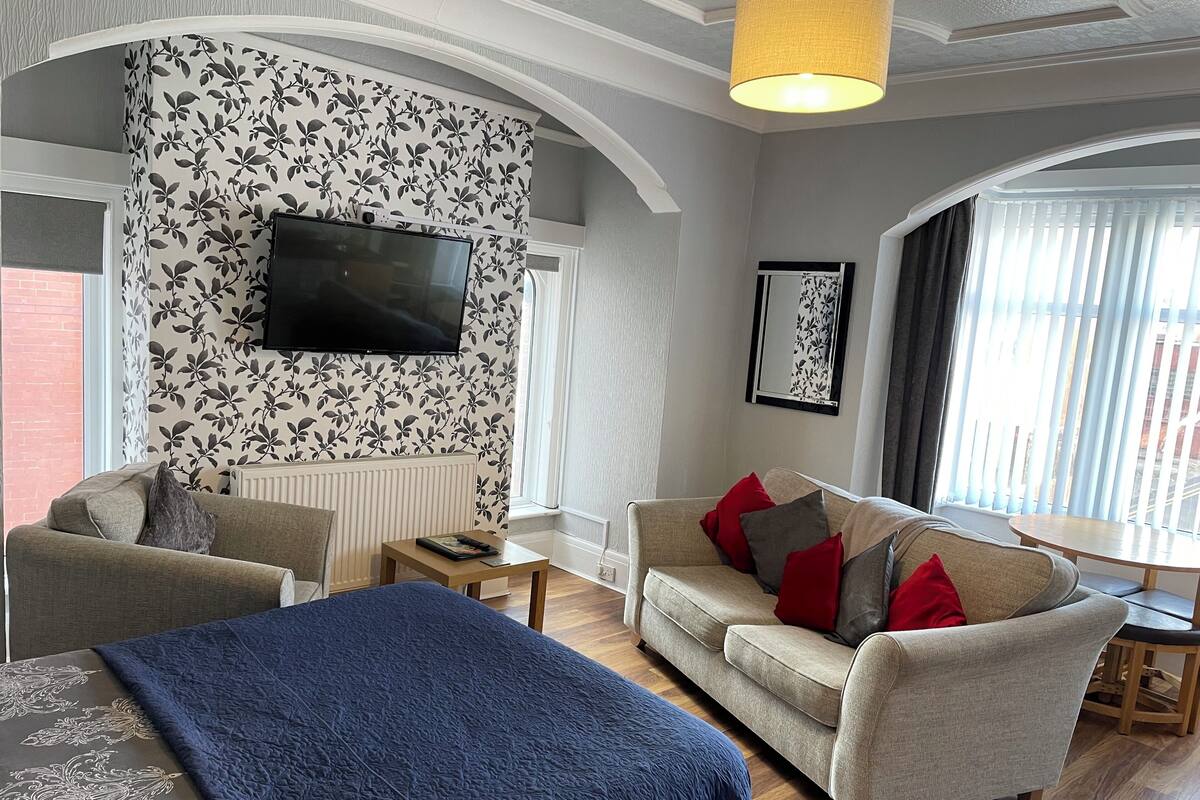 Un salon moderne avec un canapé, une table basse et un téléviseur fixé au mur.