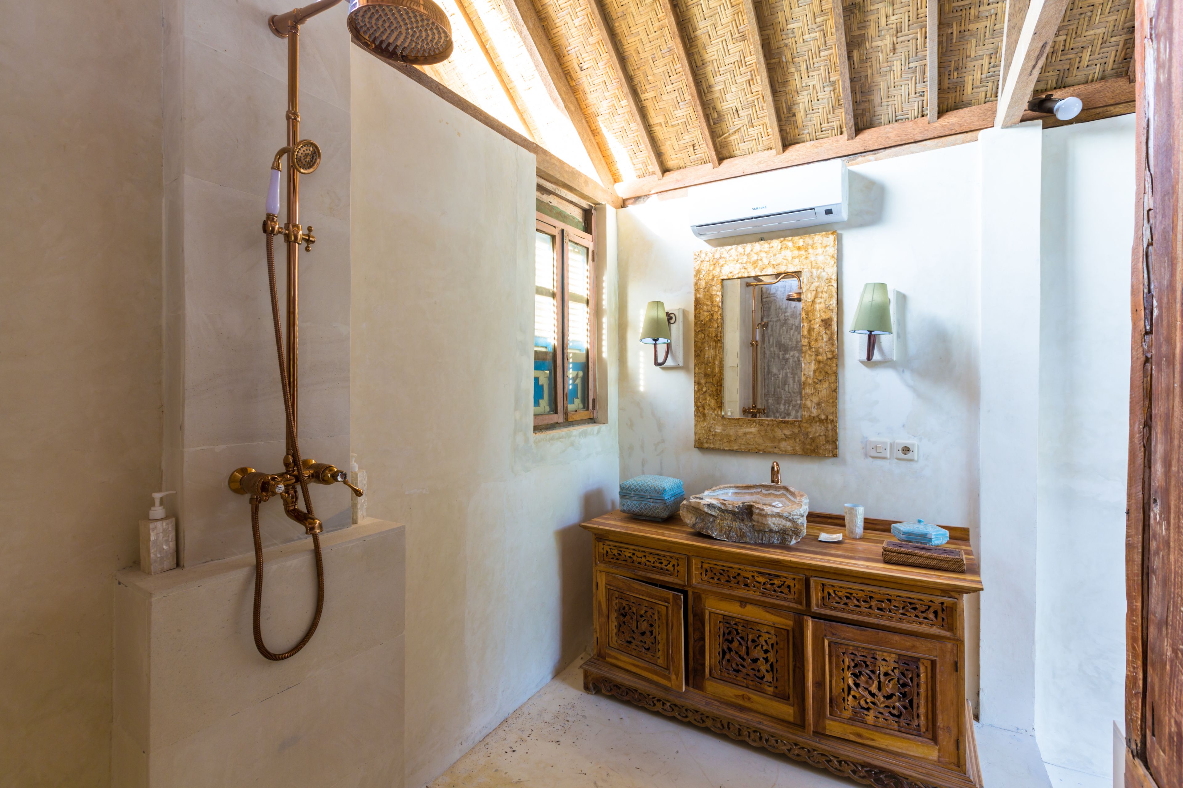 A bathroom with a shower, wooden vanity, and a mirror.