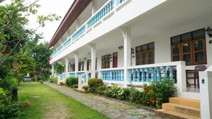 A two-story building with a covered porch, multiple windows, and a stone pathway leading to the entrance. - Weekender Bungalow (Koh Samui)