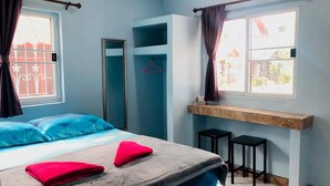 A bedroom with a bed, two nightstands, a mirror, and a window with curtains. - Weekender Bungalow (Koh Samui)