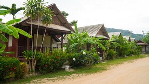 A row of wooden houses with metal roofs, surrounded by lush greenery and banana trees. - Weekender Bungalow (Koh Samui)