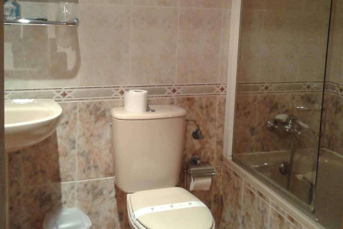 A bathroom with a toilet, sink, and shower.